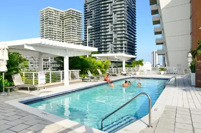 a pool with people in it with tall buildings at Stylish and Spacious Condo Prefect to Enjoy Miami! in Miami