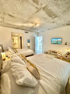a bedroom with three beds with white sheets at Stylish and Spacious Condo Prefect to Enjoy Miami! in Miami