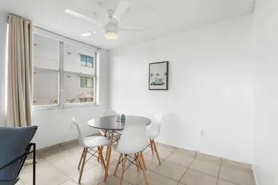 a dining room with a table and white chairs at Bay Harbor Sunset 3A in Miami Beach