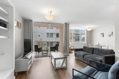 a living room with a couch and a tv at Bay Harbor Sunset Apt 3B in Miami Beach