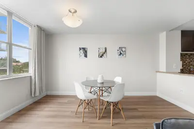 a dining room with a table and white chairs at Bay Harbor Sunset Apt 3B in Miami Beach