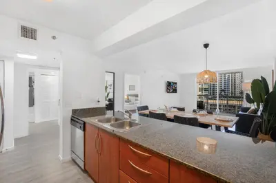 a kitchen with a sink and a dining room with a table at Stylish Brickell Condo with Stunning Views & Premier Amenities in Miami