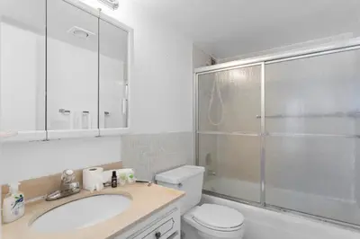 a bathroom with a toilet and a sink and a shower at Bay Harbor Sunset Apt 4B in Miami Beach