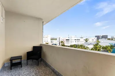 a balcony with a chair and a view of the city at Bay Harbor Sunset Apt 5A in Miami Beach