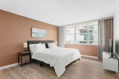 a bedroom with a bed and a television in it at Bay Harbor Sunset Apt 5B in Miami Beach