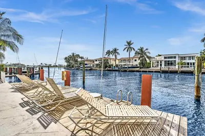 a group of chairs sitting on a dock in the water at Bay Harbor Sunset Apt 5B in Miami Beach