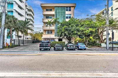 a group of cars parked in a parking lot in front of a building at Bay Harbor Sunset Apt 5B in Miami Beach