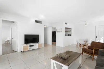 a living room with a television and a table at Bay Harbor Sunset Apt 5C in Miami Beach
