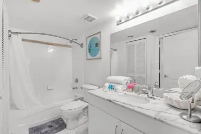 a white bathroom with a toilet and a sink at Waterfront and City Lights 1-BR With Free Parking in Miami