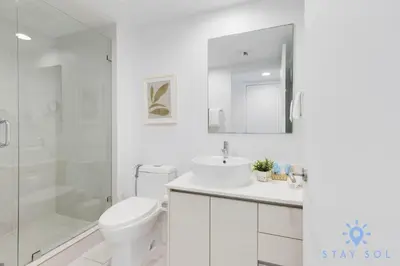 a bathroom with a toilet and a sink and a shower at Stylish Apartment Pool & Balcony in Hallandale Beach