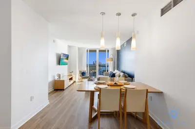 a dining room and living room with a table and chairs at Stylish Apartment Pool & Balcony in Hallandale Beach