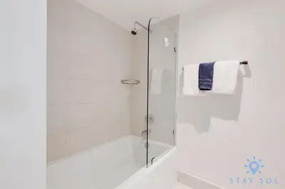 a shower with a glass door in a bathroom at Stylish Beach Apartment with Pool in Hallandale Beach