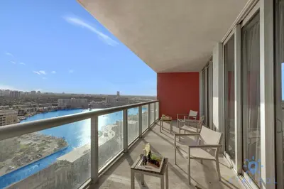 a balcony with chairs and a view of the water at Stylish Beach Apartment with Pool in Hallandale Beach