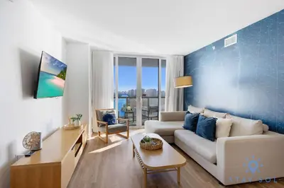 a living room with a couch and a table at Stylish Beach Apartment with Pool in Hallandale Beach