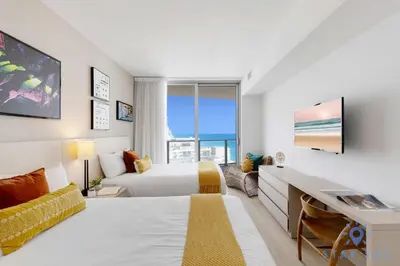 a hotel room with a bed and a desk and a bed and a couch at Apartment with Ocean View Balcony in Hollywood