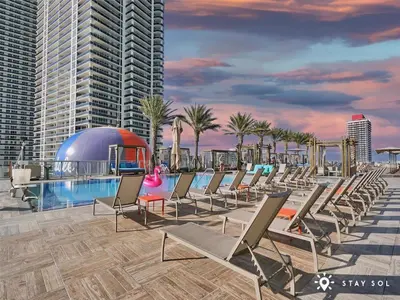 a row of lounge chairs next to a swimming pool at Apartment with Ocean View Balcony in Hollywood