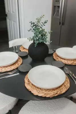 a table with white plates and a vase with a plant at Miami Oasis - Unit A in Miami