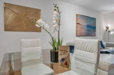 a living room with a glass table and white chairs at Cozy 1 Bedroom Apt in The Heart of Brickell in Miami