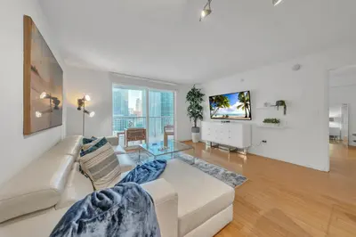 a living room with a white couch and a tv at Cozy 1 Bedroom Apt in The Heart of Brickell in Miami