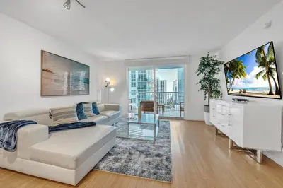 a white living room with a couch and a table at Cozy 1 Bedroom Apt in The Heart of Brickell in Miami