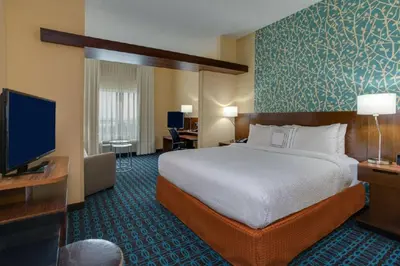 a hotel room with a bed and a flat screen tv at Fairfield Inn & Suites by Marriott Fort Lauderdale Pembroke Pines in Pembroke Pines