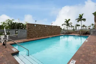 a large blue swimming pool with a brick wall at Fairfield Inn & Suites by Marriott Fort Lauderdale Pembroke Pines in Pembroke Pines