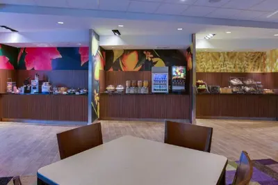 a waiting room with a table and chairs and a counter at Fairfield Inn & Suites by Marriott Fort Lauderdale Pembroke Pines in Pembroke Pines