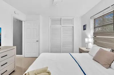a white bedroom with a large bed and a window at Luxury Heated Pool Villa Hollywood Beach & Casino in Hollywood