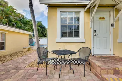 two chairs and a table in front of a house at Shared Pool and Backyard Small and Cozy Guest House in Fort Lauderdale