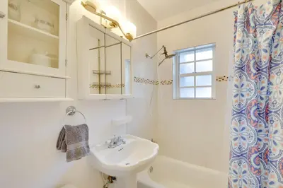 a white bathroom with a sink and a shower at House with Shared Pool Access 4 Mi to Beaches! in Fort Lauderdale