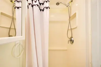a shower with a white shower curtain in a bathroom at Detached Backyard Studio in Fort Lauderdale! in Fort Lauderdale