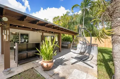 a patio with a swing and a chair at Turtle Nest Bungalow in Fort Lauderdale