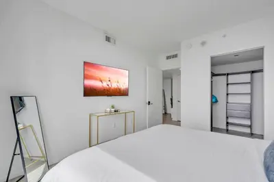 a white bedroom with a bed and a painting on the wall at Great 3 beds 3 baths Appartment Downtown Miami in Miami