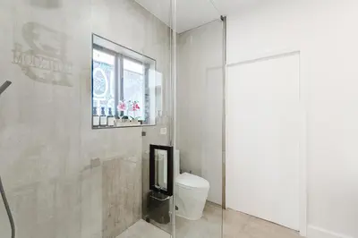 a bathroom with a toilet and a window at Prime Location 4BR Villa with Pool in Miami