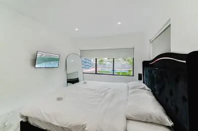 a bedroom with a large bed with a large window at Prime Location 4BR Villa with Pool in Miami
