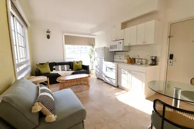 a kitchen and living room with a couch and a table at Art Deco 1 Bedroom Apartment Steps to Beach in South of Fifth Neighborhood in Miami Beach