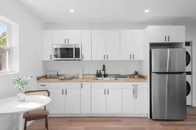 a kitchen with white cabinets and a stainless steel refrigerator at 921 Apartment 1 in Fort Lauderdale