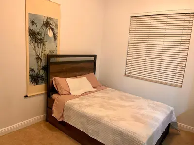 a small bed in a room with a window at Two private rooms with private bathroom in shared House in Fort Lauderdale