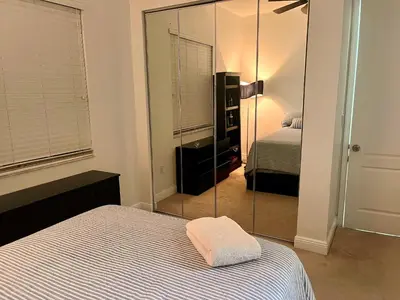 a bedroom with a mirror next to a bed at Two private rooms with private bathroom in shared House in Fort Lauderdale