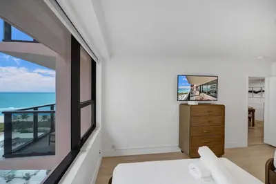 a bedroom with a view of the ocean at Chic 2-Bedroom Condo with Beach Service & Gym / 1210 in Miami Beach