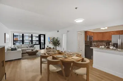 a kitchen and living room with a table and chairs at Chic 2-Bedroom Condo with Beach Service & Gym / 1210 in Miami Beach