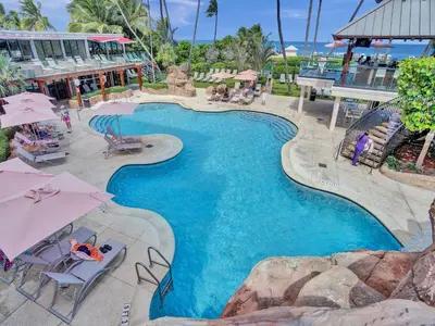 a swimming pool with chairs and umbrellas at a resort at Ocean View Spacious 2 BDR Condo Beach Service 609 in Miami Beach