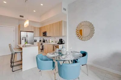 a kitchen with a glass table and blue chairs at 3900-604LG DESIGN DISTRICT, CONDO 1 BEDROOM & 1 BATHROOM in Miami