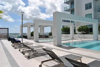 a swimming pool with chaise lounge chairs next to a building at 3900-604LG DESIGN DISTRICT, CONDO 1 BEDROOM & 1 BATHROOM in Miami