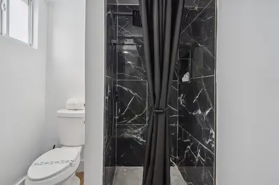 a bathroom with a shower with black marble tiles at Casa Roselle 3 Bedrooms in Hollywood