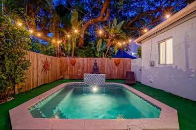 a swimming pool in a backyard with a fence and lights at Buddha House Pool Big Yard in Miami