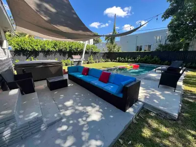 a blue couch sitting next to a swimming pool at Wynwood House With Pool, Hotub and Parking in Miami