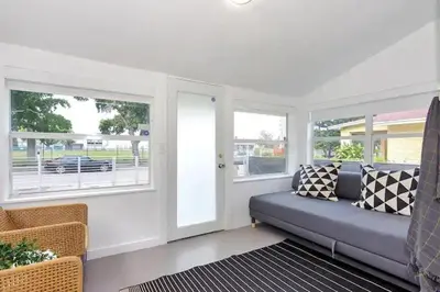 a living room with a couch and two windows at Wynwood House With Pool, Hotub and Parking in Miami