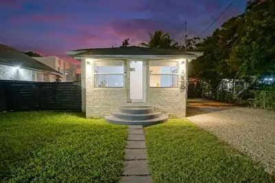 a small brick house with a white door in a yard at Wynwood House With Pool, Hotub and Parking in Miami