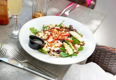 a salad in a white plate on a table at North Beach Hotel in Fort Lauderdale
